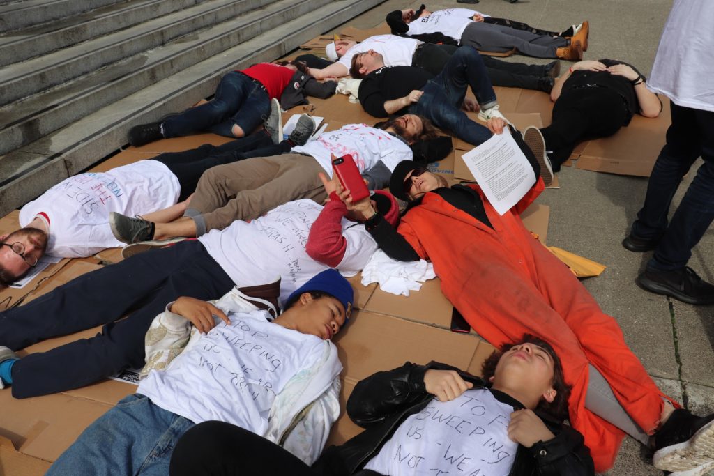 Activists lie on the ground in protest of the city's inhumane homeless "sweeps"