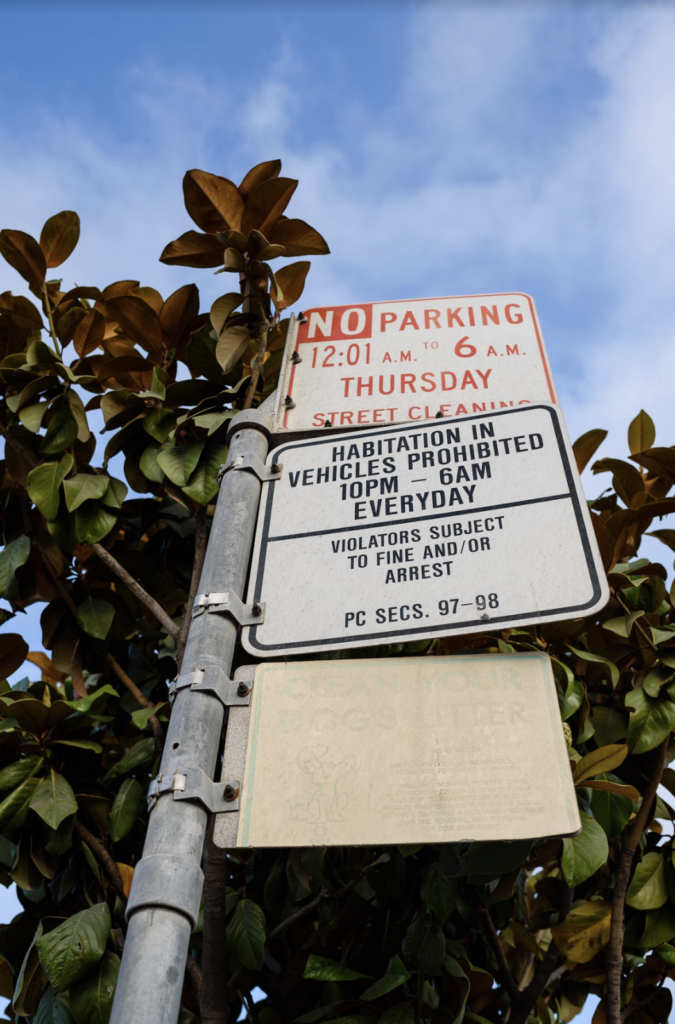 A posted sign prohibits "habitation in vehicles" between 10pm and 6am everyday, and says "violators subject to fine and/or arrest"