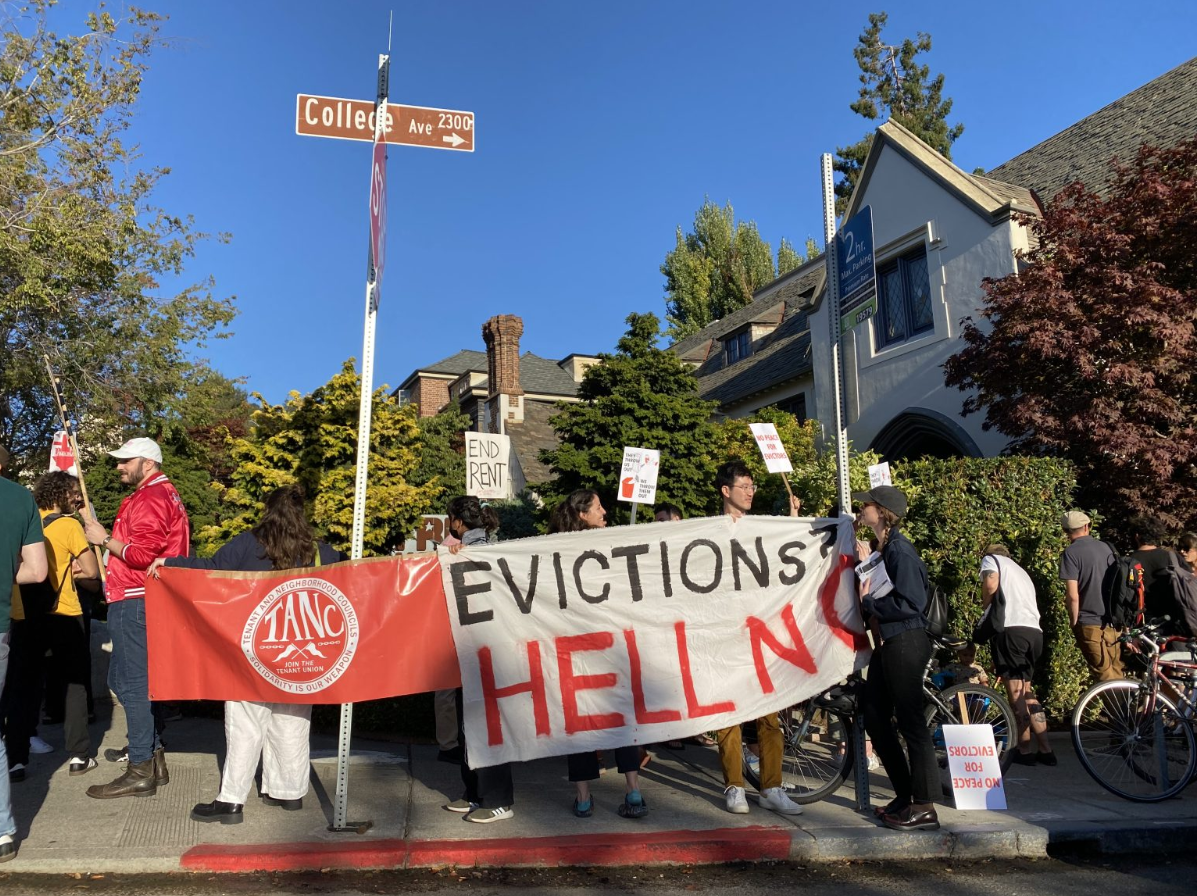Protesters holding banner reading "Evictions? Hell No"