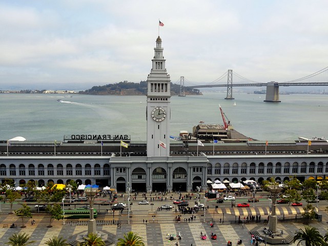 A photo of the Ferry building, with the Bay Bridge and Treasure Island behind it.