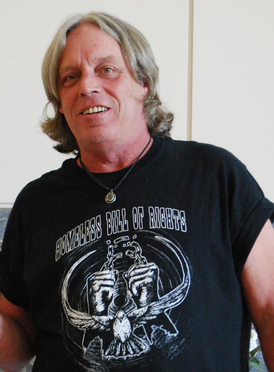 Man with shoulder-length hair wearing a shirt that read "Homeless Bill of Rights"