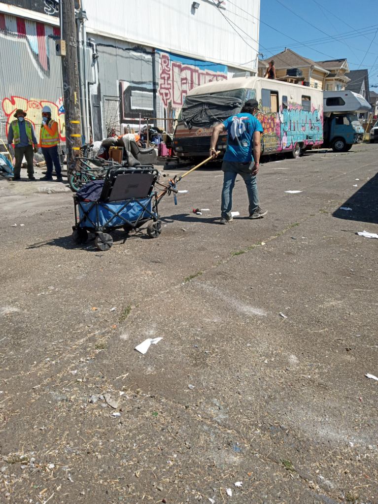 Man pulling a wagon near RV site in Oakland, CA